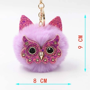 Detail view of purple plush owl keychain measuring 9 cm by 8 cm with golden metal ring