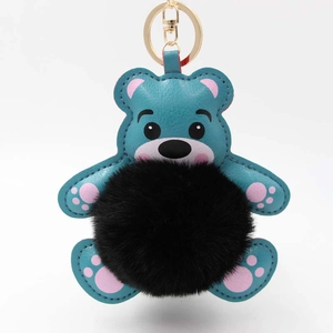 Detailaufnahme von Teddybär-Schlüsselanhänger aus blauem Leder mit schwarzem Plüschball