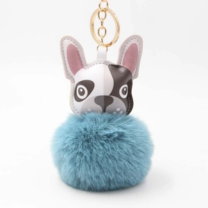 Detail eines blauen Bommel Schlüsselanhängers mit Bulldoggen Lederkopf und Goldring