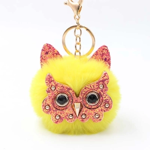 Cute yellow plush owl keychain with pink glitter ears and gold clasp on white background