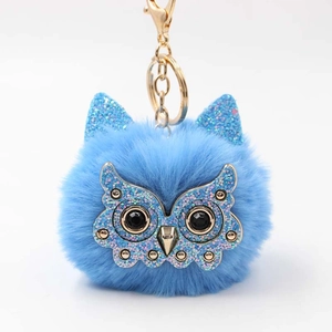 Detail of light blue owl pom-pom keychain with glitter ears and gold lobster clasp