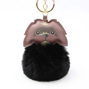 Cute puppy plush keychain with black faux fur pompom and leather detail on white background