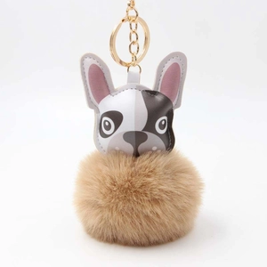 Detail eines süßen Bulldogge-Plüschanhängers mit braunem Pelzball und Goldring