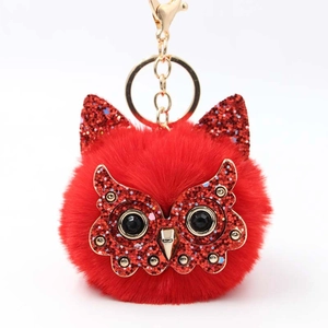 Detailed view of red plush owl keychain with glitter fabric and gold lobster clasp