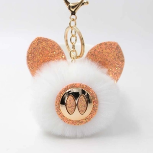 Détail du porte-clés cochon en peluche blanc avec paillettes orange et fermoir doré