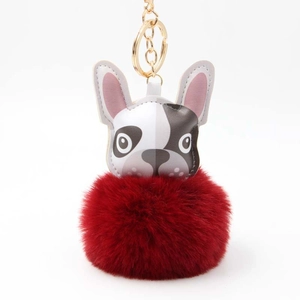 Detail eines Leder-Bulldoggen-Schlüsselanhängers mit flauschigem rotem Kunstfell-Bommel