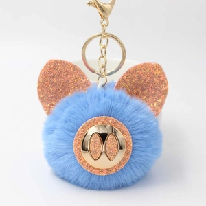 Vue détaillée du porte-clés cochon en peluche bleue avec paillettes roses et attache dorée