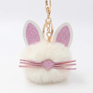 Detail view of white faux fur bunny keychain with pink glitter ears and gold metal clasp