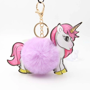 Detail of purple pom-pom unicorn keychain with gold metal clasp and colorful pony charm