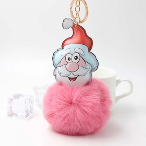 Close-up of a Santa Claus plush keychain with a pink pompom and gold metal ring
