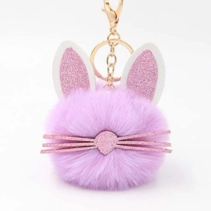 Macro view of purple faux fur bunny keychain with glittery pink ears and gold metal clip