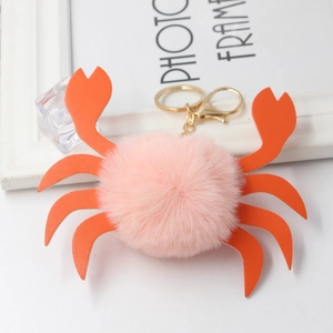 Dettaglio portachiavi a granchio in peluche rosa con zampe in finta pelle e gancio oro