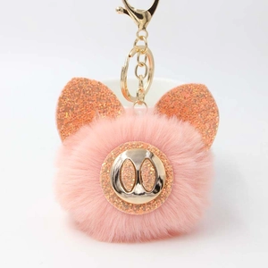 Détail du porte-clés cochon en peluche rose avec paillettes orange et fermoir doré