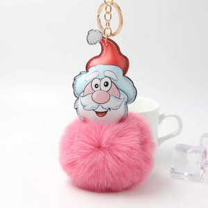 Cartoon Santa Claus plush pompom keychain with golden metal ring on white background