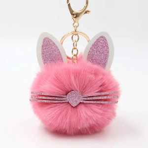 Detailed close-up of pink fluffy rabbit keychain with glitter ears and gold hardware