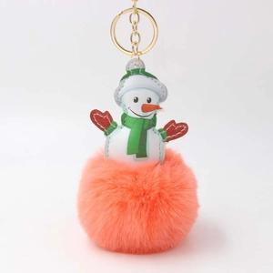 Detailansicht eines Schneemann-Anhängers mit orangefarbenem Plüschball und Goldring