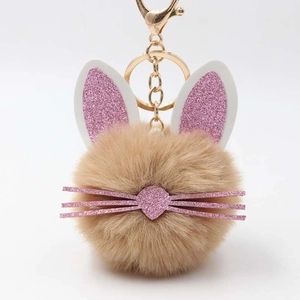 Detail of cute rabbit plush keychain with soft brown faux fur and pink glitter ears