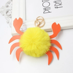 Dettaglio del portachiavi a granchio in peluche giallo con chele in ecopelle arancione e gancio