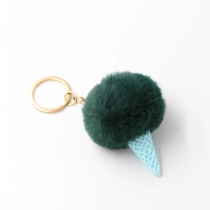 Close-up of green plush pompom ice cream keychain with blue cone and gold ring