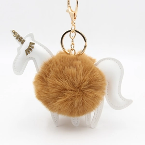Unicorn keychain with brown plush pompom and white faux leather accents on white background