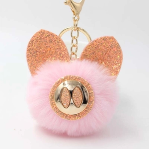 Détail d'un porte-clés cochon rose en peluche avec oreilles pailletées et fermoir doré