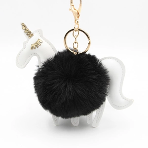 Detail of unicorn keychain with white leather and a fluffy black faux fur pompom