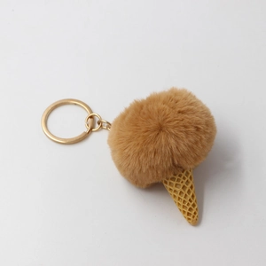 Detail of a brown plush ball ice cream keychain with yellow waffle cone and golden ring