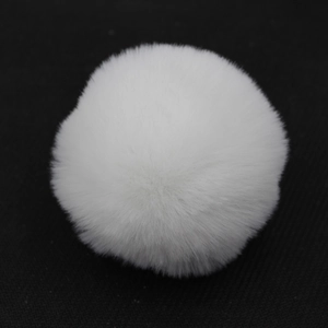 Dettaglio di un pompon di pelliccia sintetica bianca soffice per borse e portachiavi
