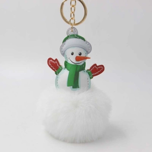 Detailansicht eines flauschigen Schneemann-Schlüsselanhängers mit grüner Mütze