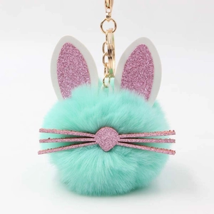 Close-up of mint green bunny pompom keychain with rose gold metal ring and pink ears