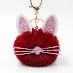 Detail of cute dark red fluffy bunny pompom keychain with glitter ears and gold lobster clasp