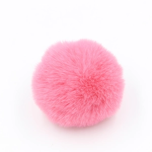 Dettaglio del pompon in finta pelliccia rosa che mostra la consistenza morbida