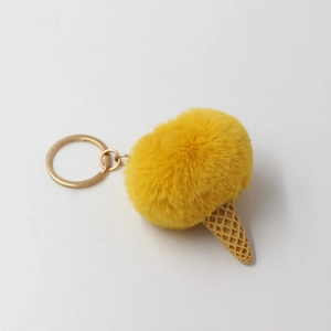 Close-up of yellow faux fur pompom ice cream keychain with a textured resin cone