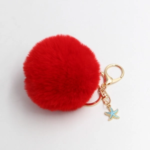 Detail of red plush ball keychain with golden lobster clasp and blue starfish charm