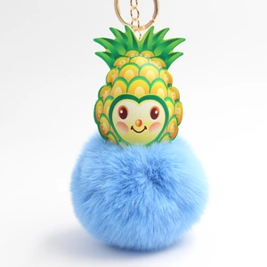 Detail eines kreativen Ananas-Plüsch-Schlüsselanhängers mit blauem Fellball und Goldclip
