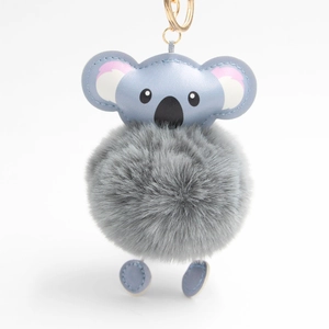 Detail of cute koala plush keychain with grey fur ball and blue leather accents