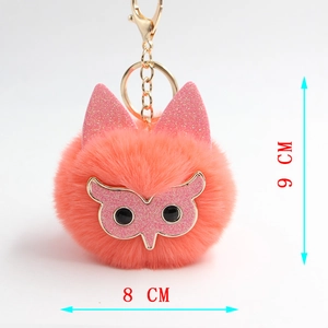Détail du porte-clés hibou en peluche rose avec oreilles pailletées et fermoir doré