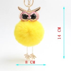 Detail showing bright yellow faux fur owl keychain with enamel head and 14cm dimensions