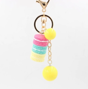 Detailed close-up of macaron resin keychain with pink green and yellow models