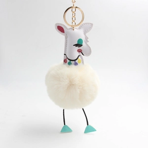 Détail du porte-clés girafe en peluche avec pompon crème et anneau doré brillant