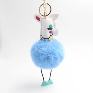 Détail du porte-clés alpaga à pompon bleu moelleux avec similicuir blanc et anneau doré