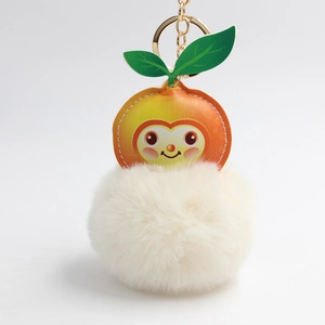 Detail of cute cartoon orange PU leather piece and large soft white faux fur pompom keychain