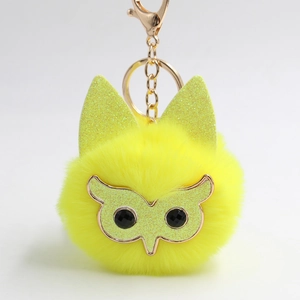 Détail du porte-clés hibou pompon jaune avec oreilles pailletées et fermoir doré chic