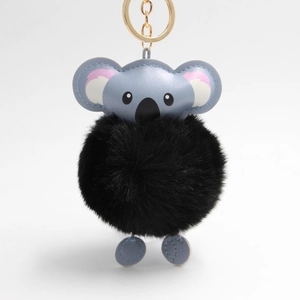 Detail of light blue leather koala keychain with large black faux fur pom pom and gold ring