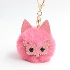 Détail du porte-clés pompon hibou rose avec oreilles à paillettes et fermoir doré