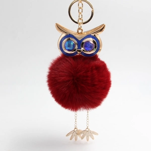 Detail of red faux fur owl keychain with crystal eyes and golden metal claws