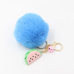 Porte-clés pompon en fourrure bleue avec breloque pastèque et clochette sur anneau doré