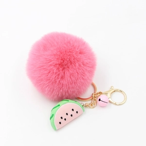 Détail du porte-clés en peluche rose avec breloque pastèque et fermoir doré