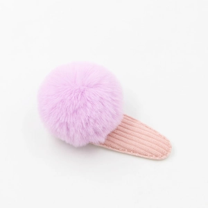 Détail du pompon en peluche violet et du clip BB en velours rose à texture douce