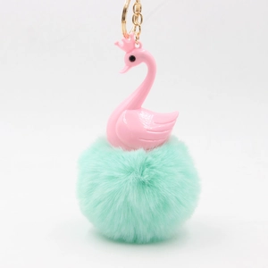 Pink swan plush keychain with crown and mint green faux fur pompom on gold ring